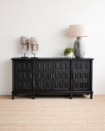 Black sideboard with decorative items against a white wall