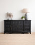 Black sideboard with decorative items against a white wall