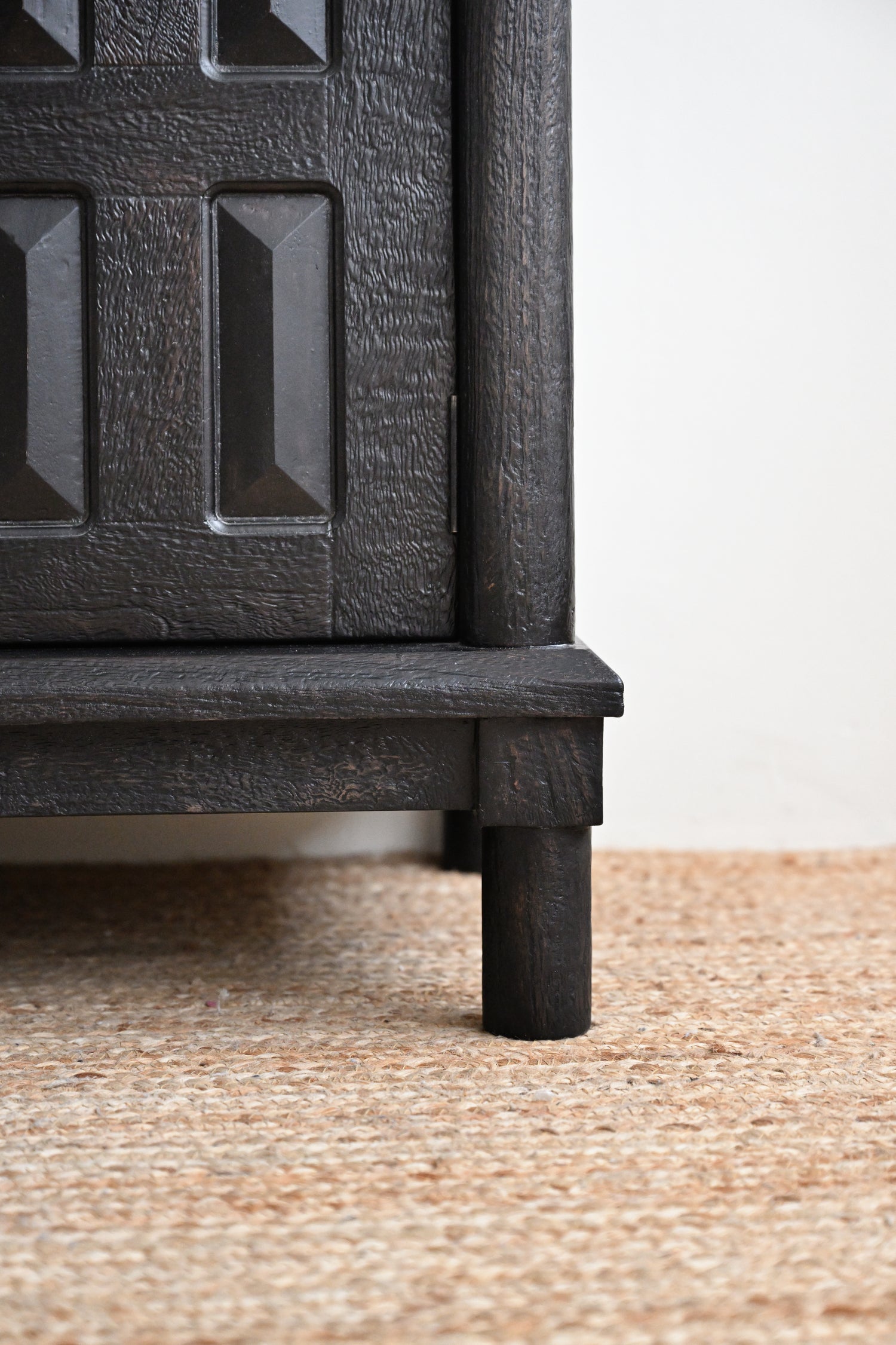 Close-up of a textured black radiator on a beige carpet