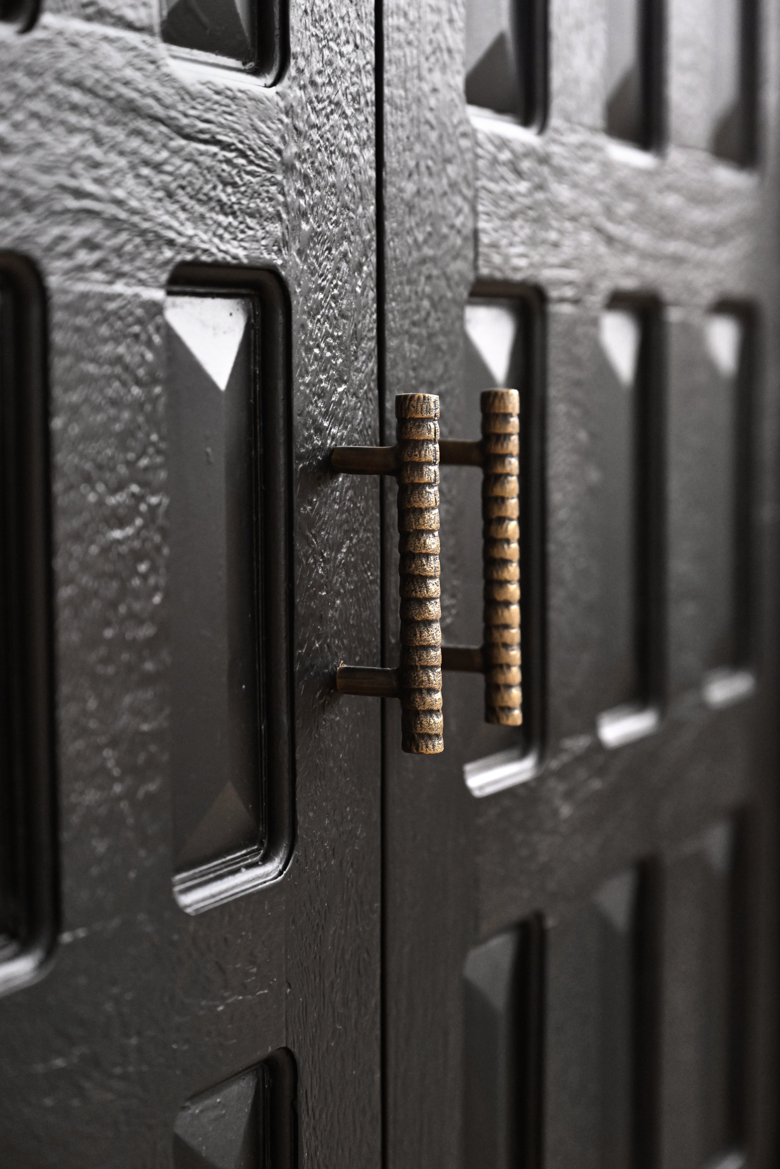 Close-up of a textured metal surface with a bronze handle