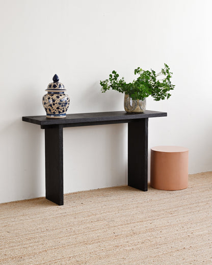 Black console table with decorative items against a white wall