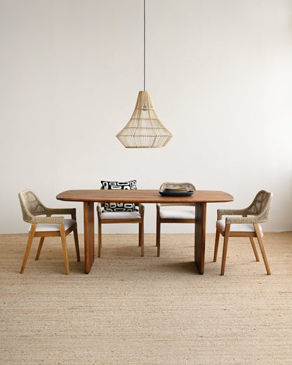 Dining area with wooden table and chairs under a pendant light in a minimalistic room.