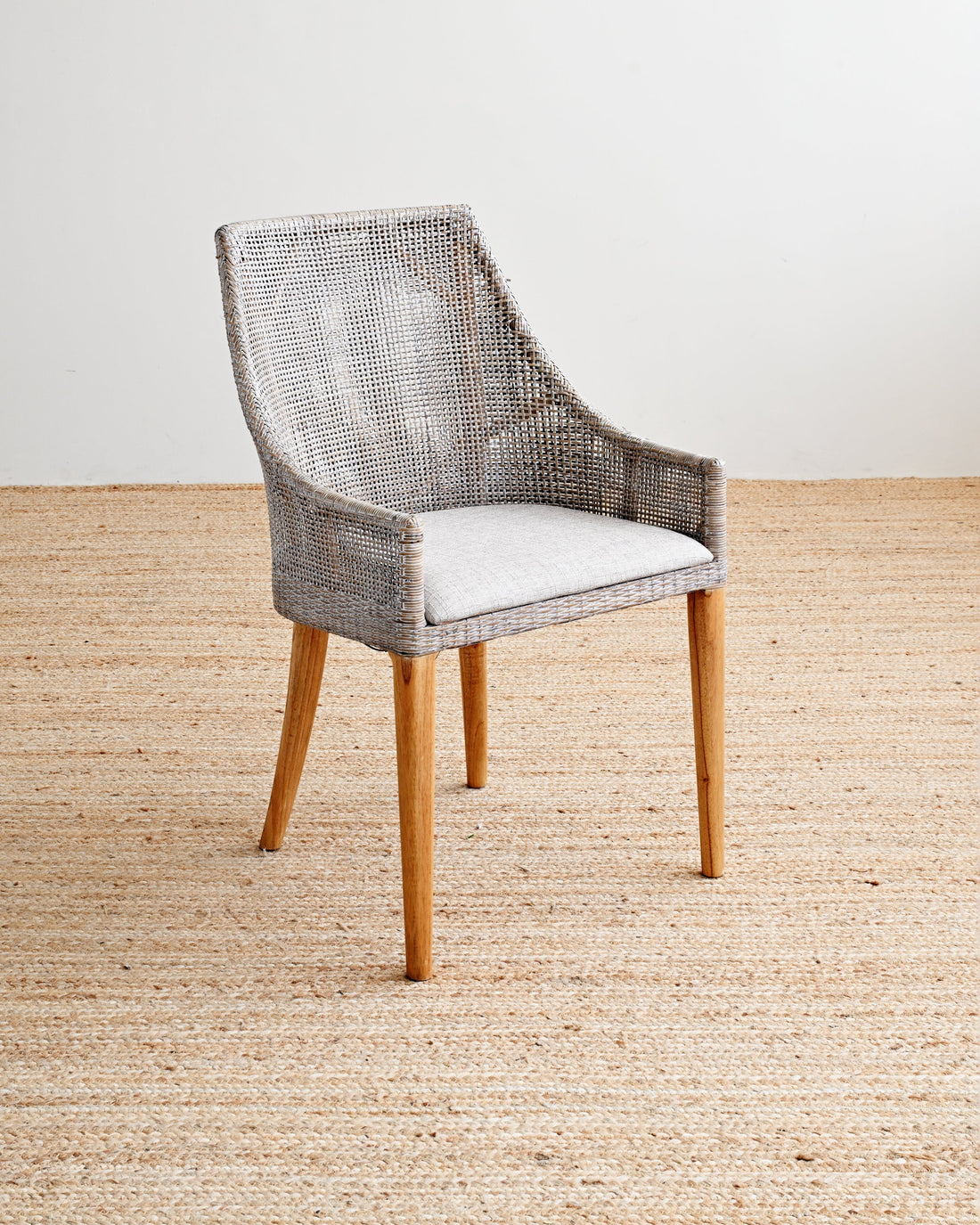 Chair with woven backrest and wooden legs on a beige carpet