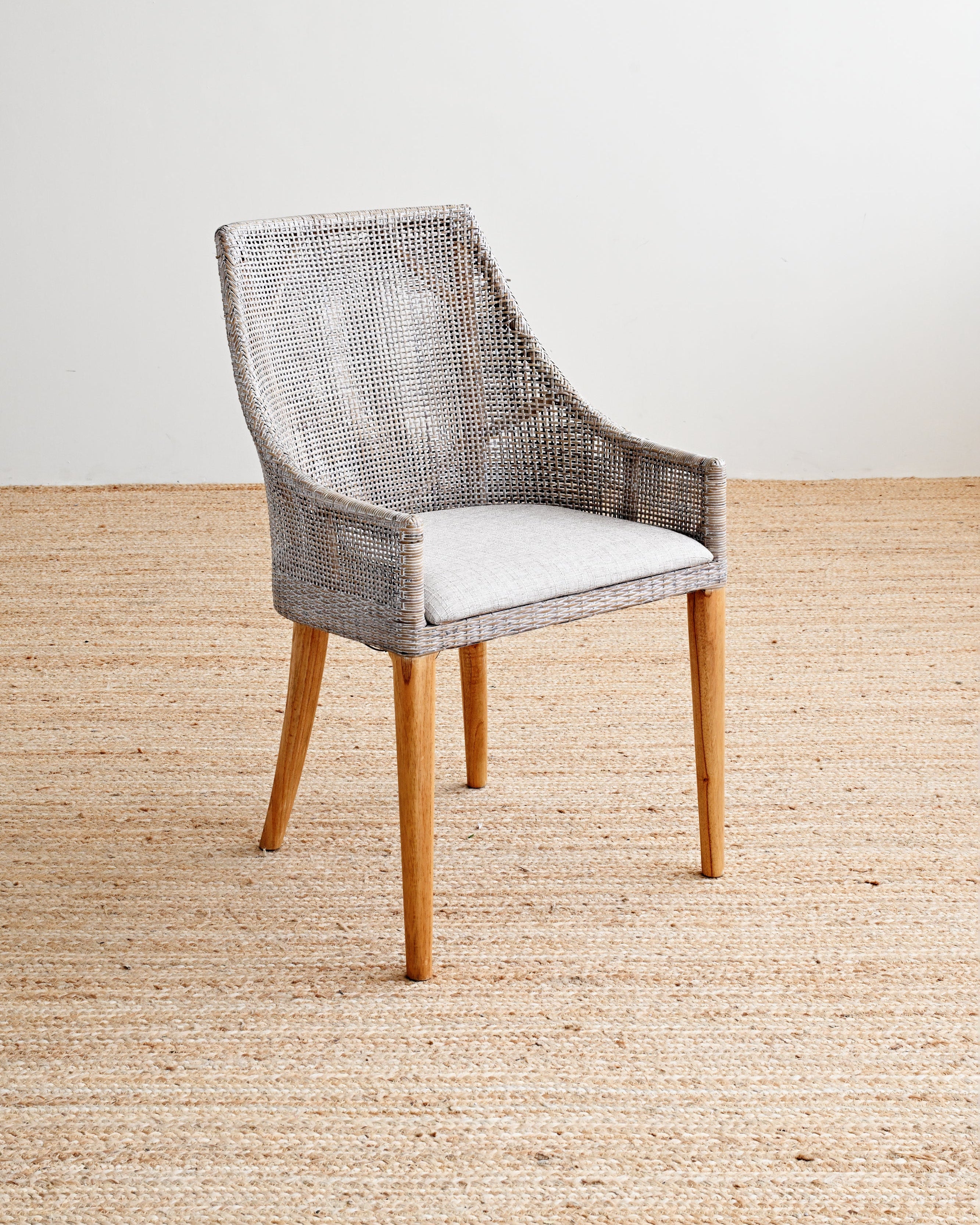 Chair with woven backrest and wooden legs on a beige carpet