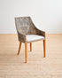 Wicker chair with a white cushion on a wooden floor.
