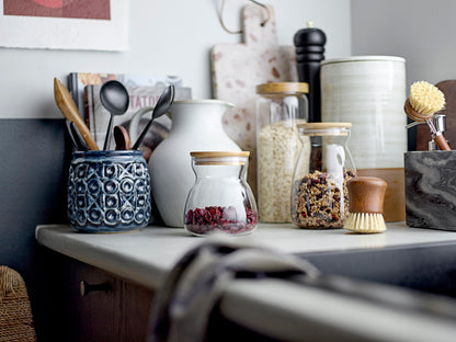 Kitchen counter with various jars, utensils, and kitchen items.