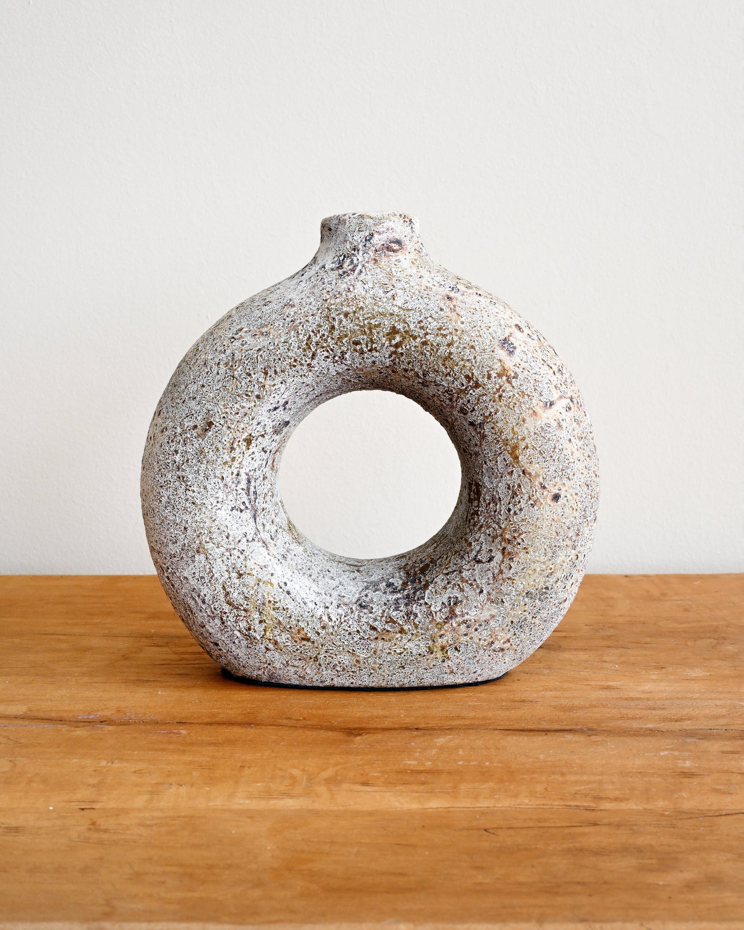 Ceramic vase with textured surface on a wooden surface