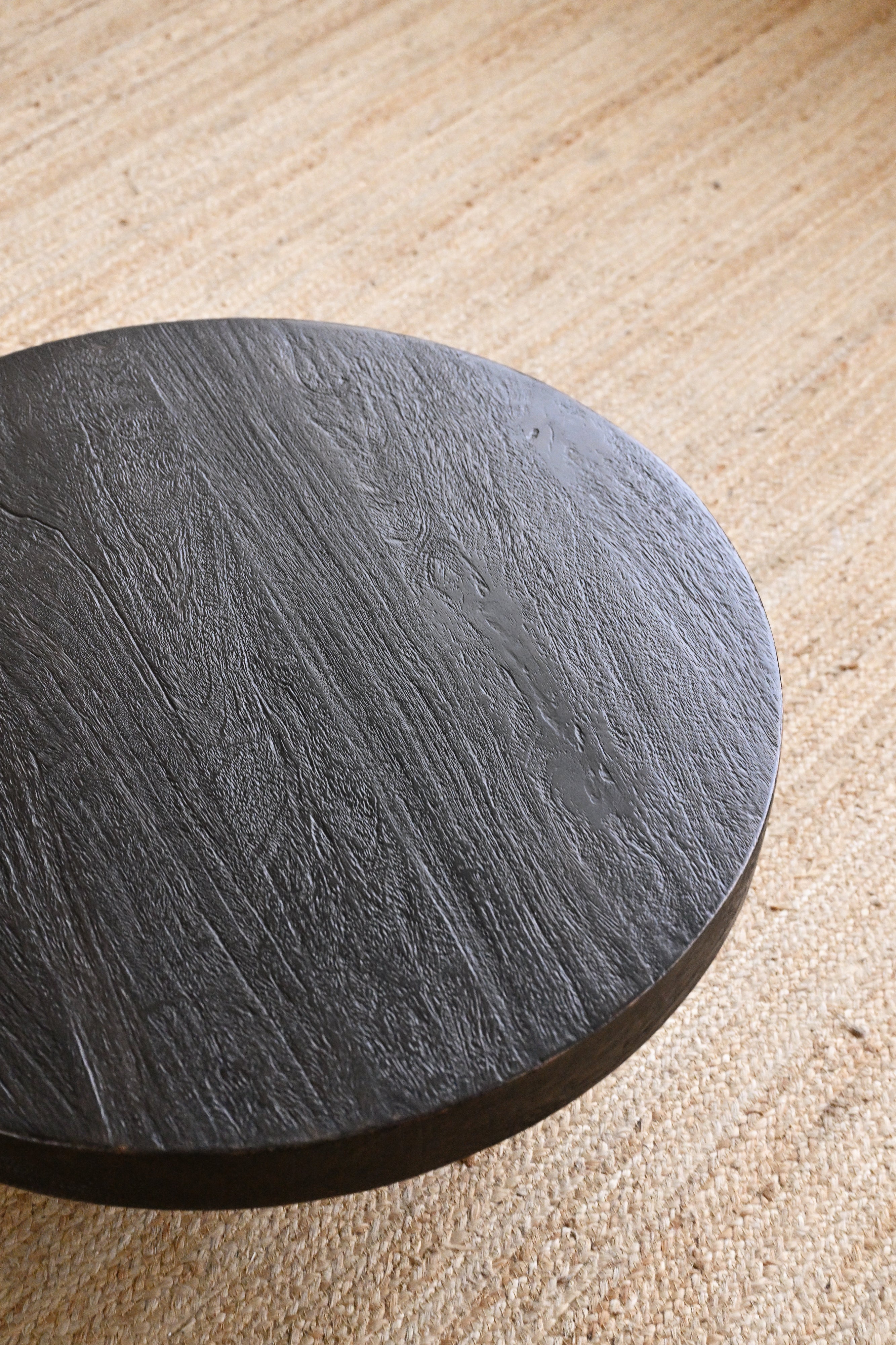 Round black stone coaster on a beige surface