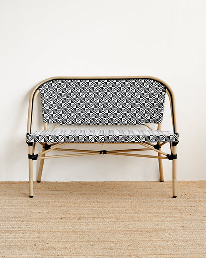 Small bench with black and white patterned seat on a beige floor.