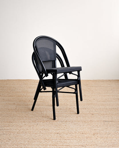 Black chair on a beige carpet with a white wall background