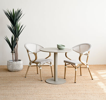 Modern dining area with a round table and chairs in a minimalistic setting.