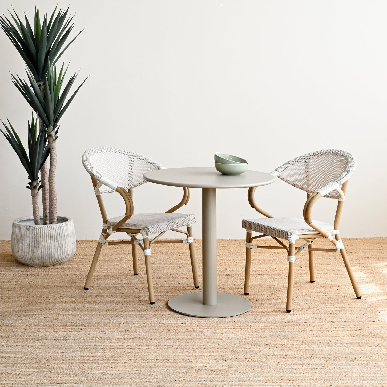 Modern dining area with a round table and chairs in a minimalistic setting.