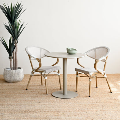 Modern dining area with a round table and chairs in a minimalistic setting.