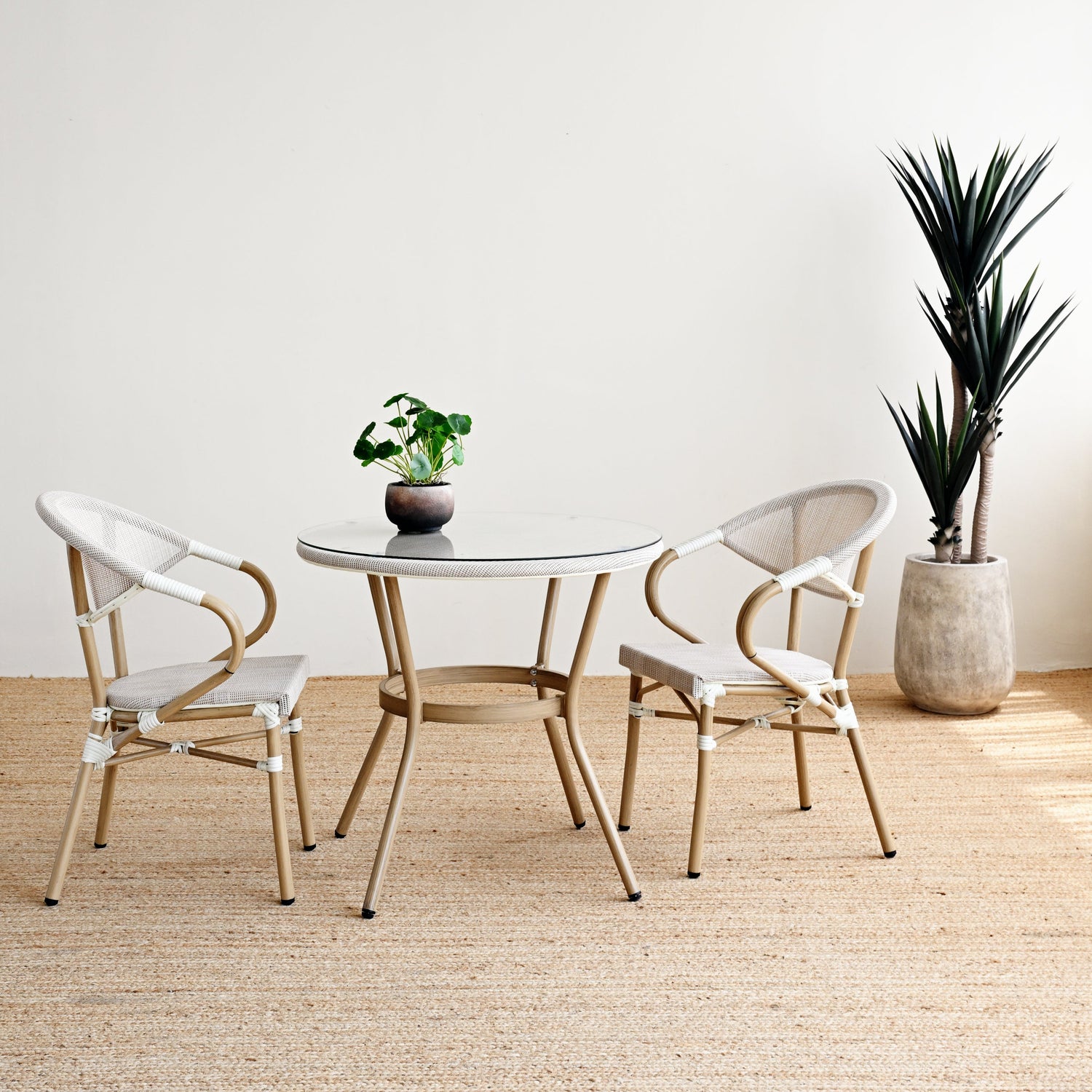 Modern dining set with round table and chairs in a minimalistic room.
