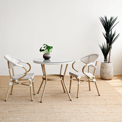 Modern dining set with round table and chairs in a minimalistic room.