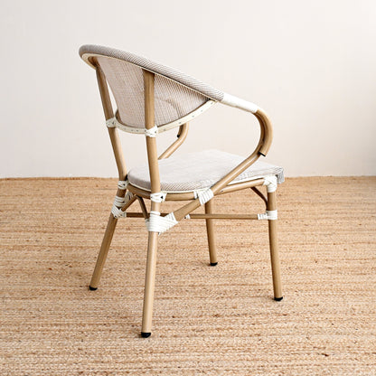 Beige chair with a white cushion on a textured beige floor and light gray wall