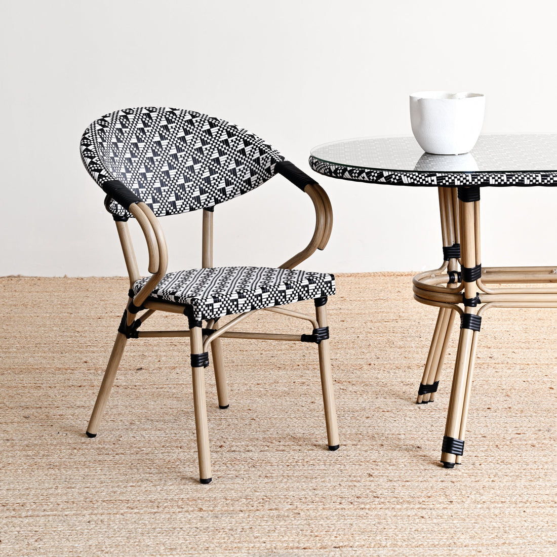 Chair and table with black and white patterned seats and legs on a beige floor.