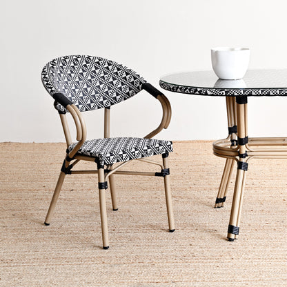 Chair and table with black and white patterned seats and legs on a beige floor.