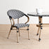 Chair and table with black and white patterned seats and legs on a beige floor.