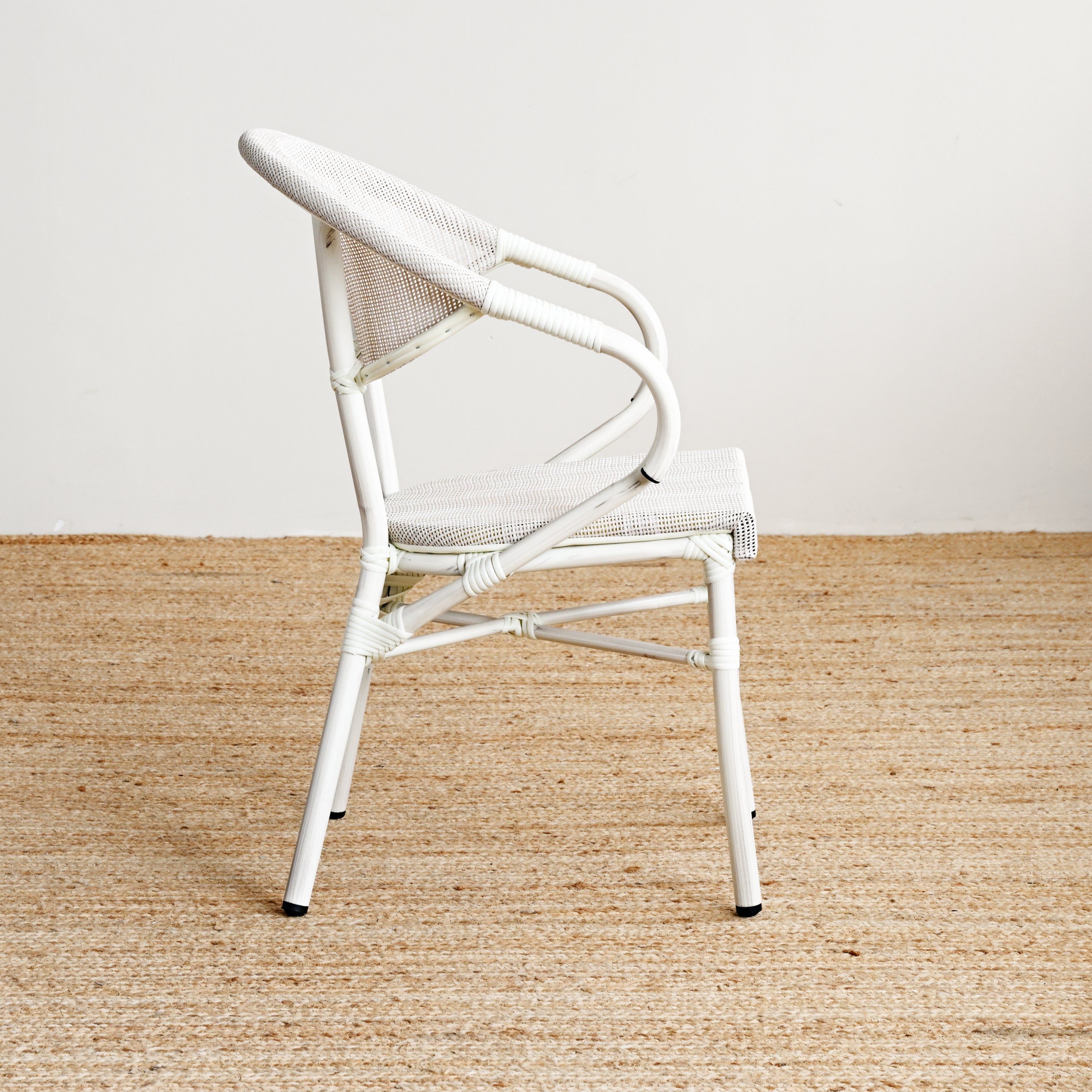 White chair on a beige carpet with a white wall background
