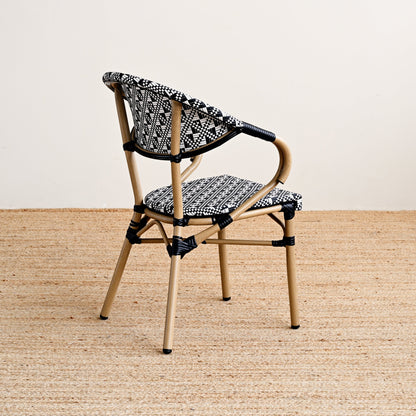 Chair with woven backrest and patterned cushion on a beige floor.
