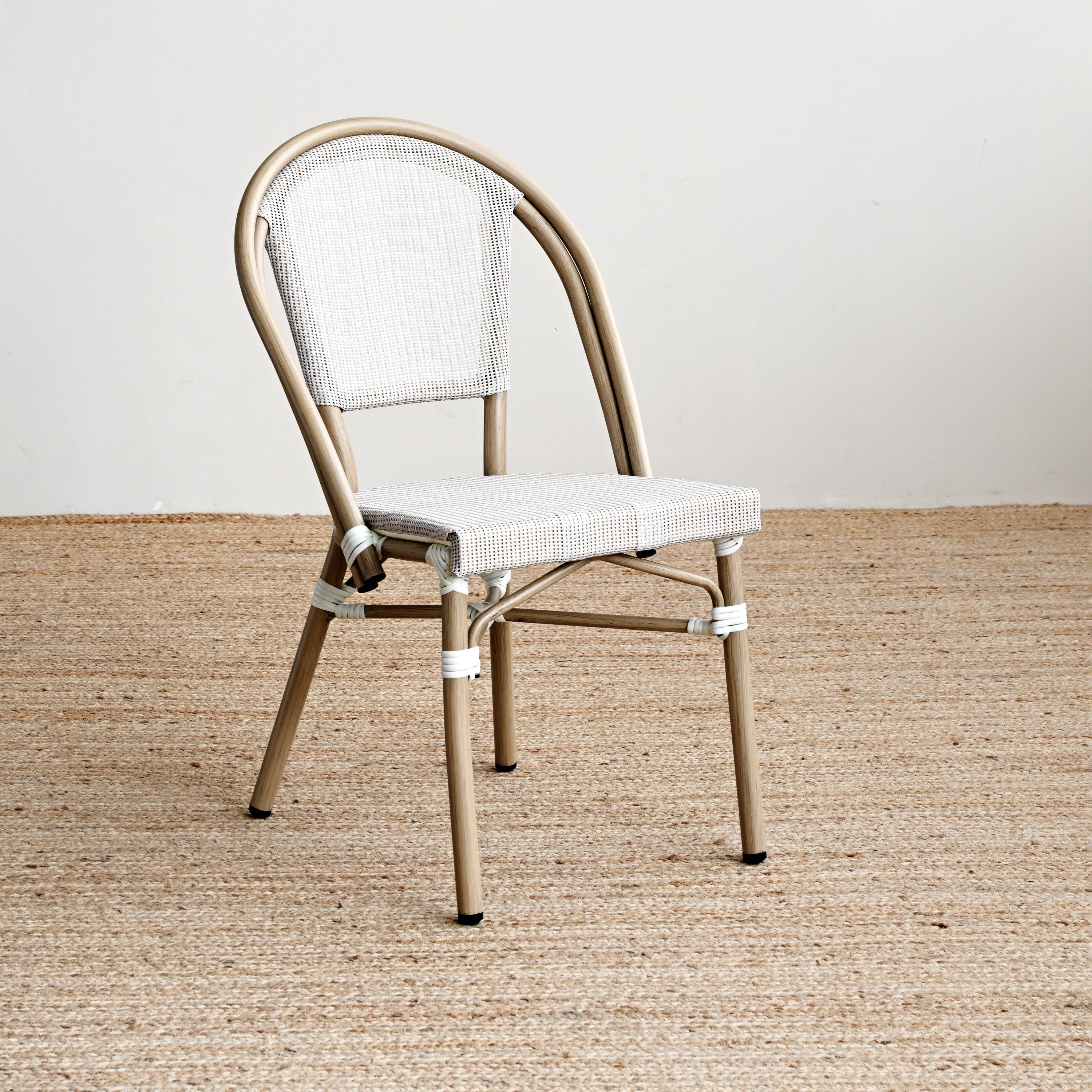 Beige metal chair with white cushion on a beige carpet