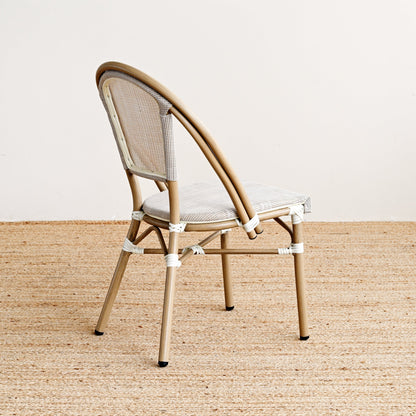 Beige chair with woven backrest on a beige carpet