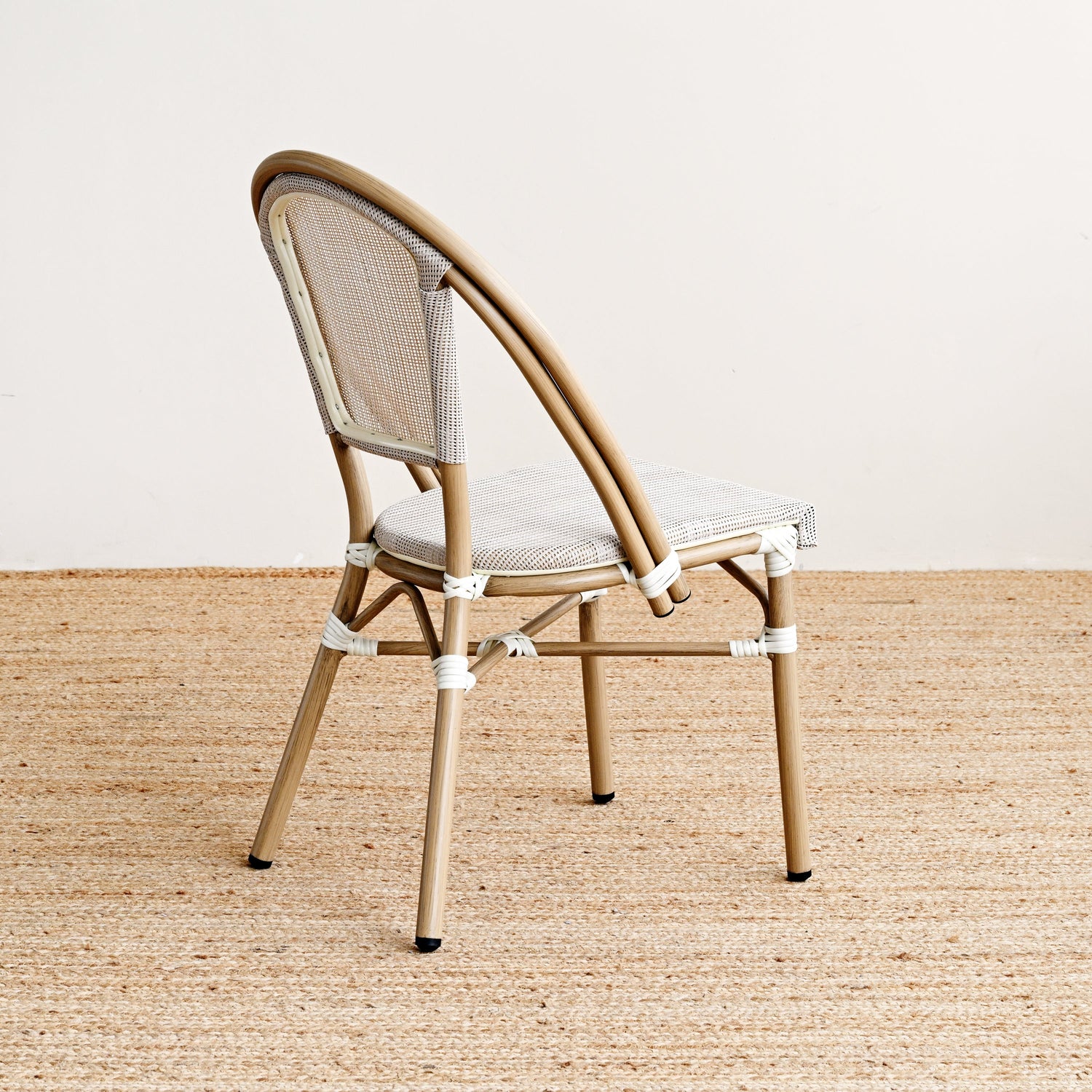 Beige chair with woven backrest on a beige carpet