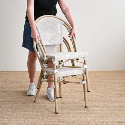 Person assembling a wooden chair on a beige carpeted floor.