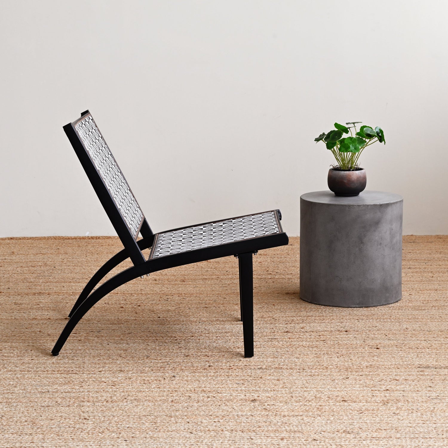 Black chair and concrete table with plant on a wooden floor