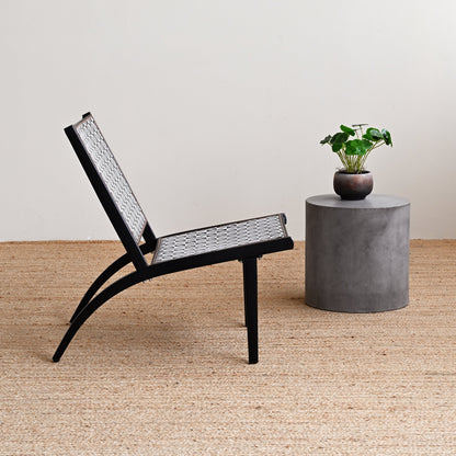 Black chair and concrete table with plant on a wooden floor