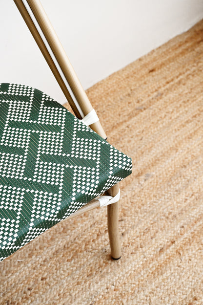 Chair with green and white patterned seat on a wooden floor