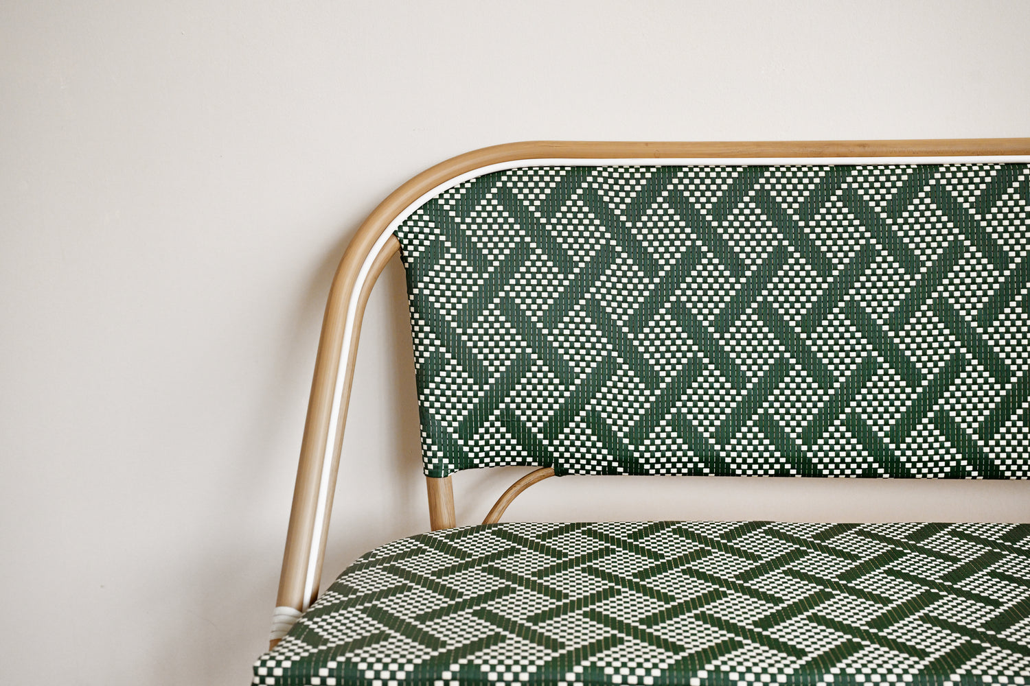 Chair with green and white patterned fabric and gold frame against a plain background