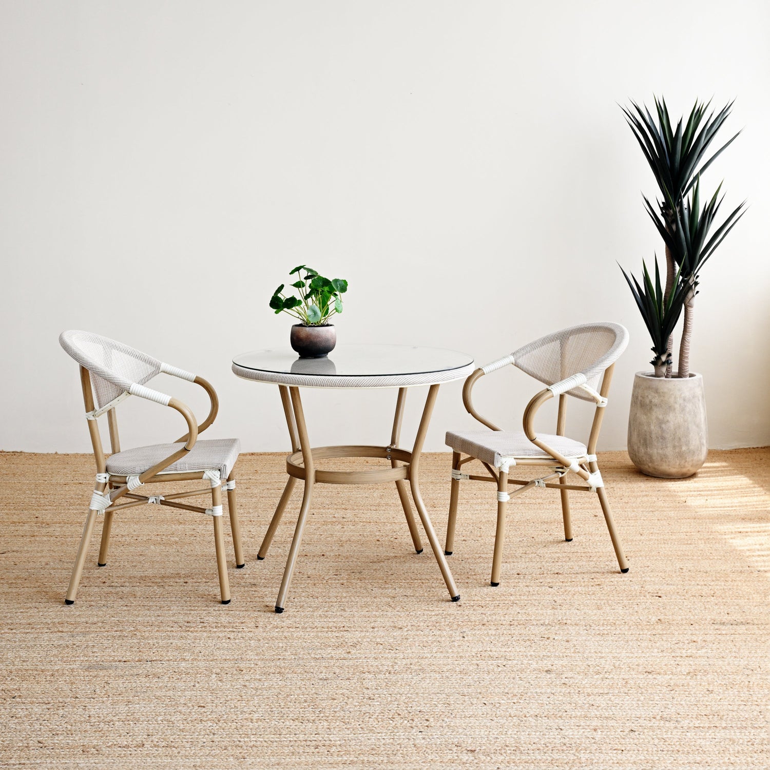 Modern dining set with round table and chairs in a minimalistic room.