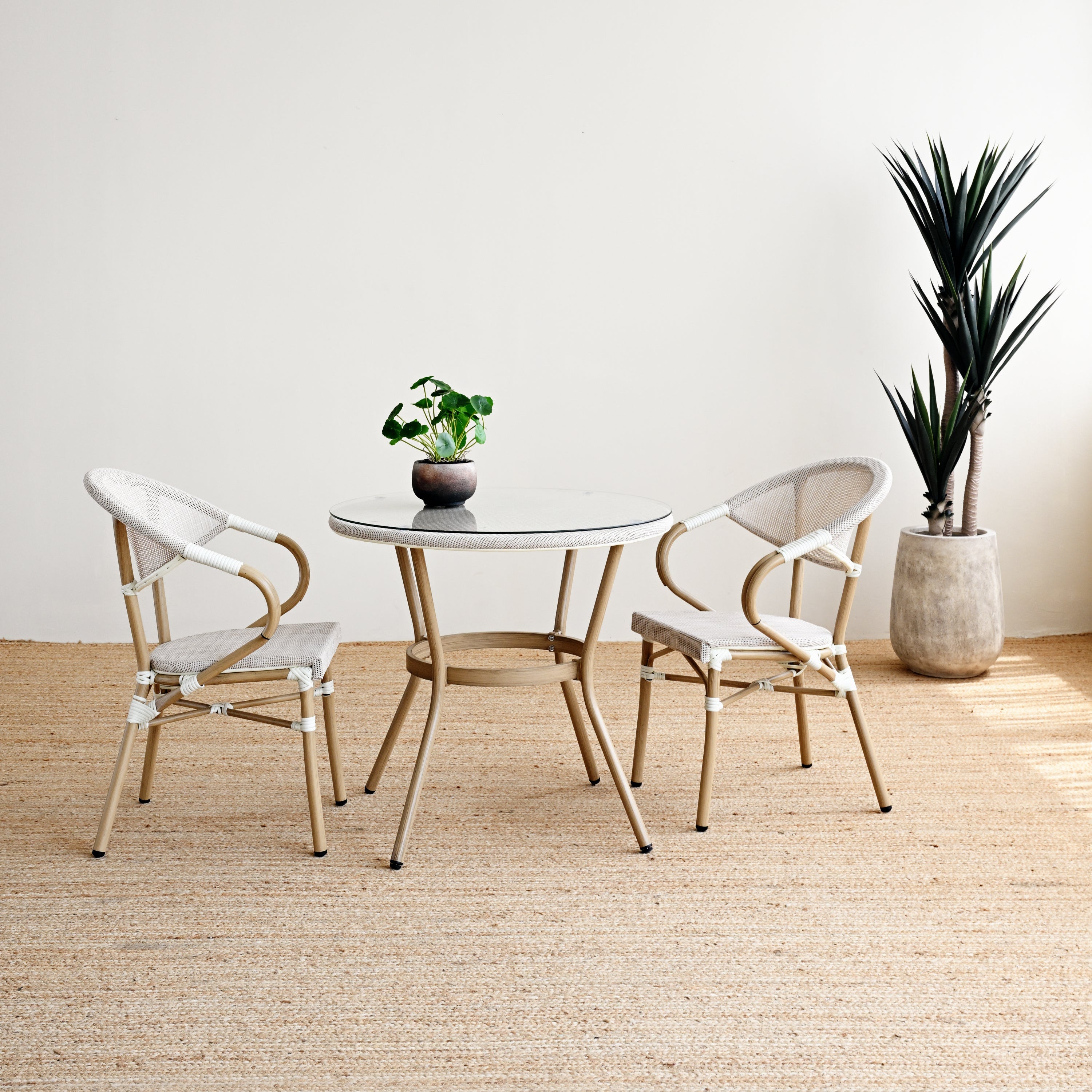 Modern dining set with round table and chairs in a minimalistic room.