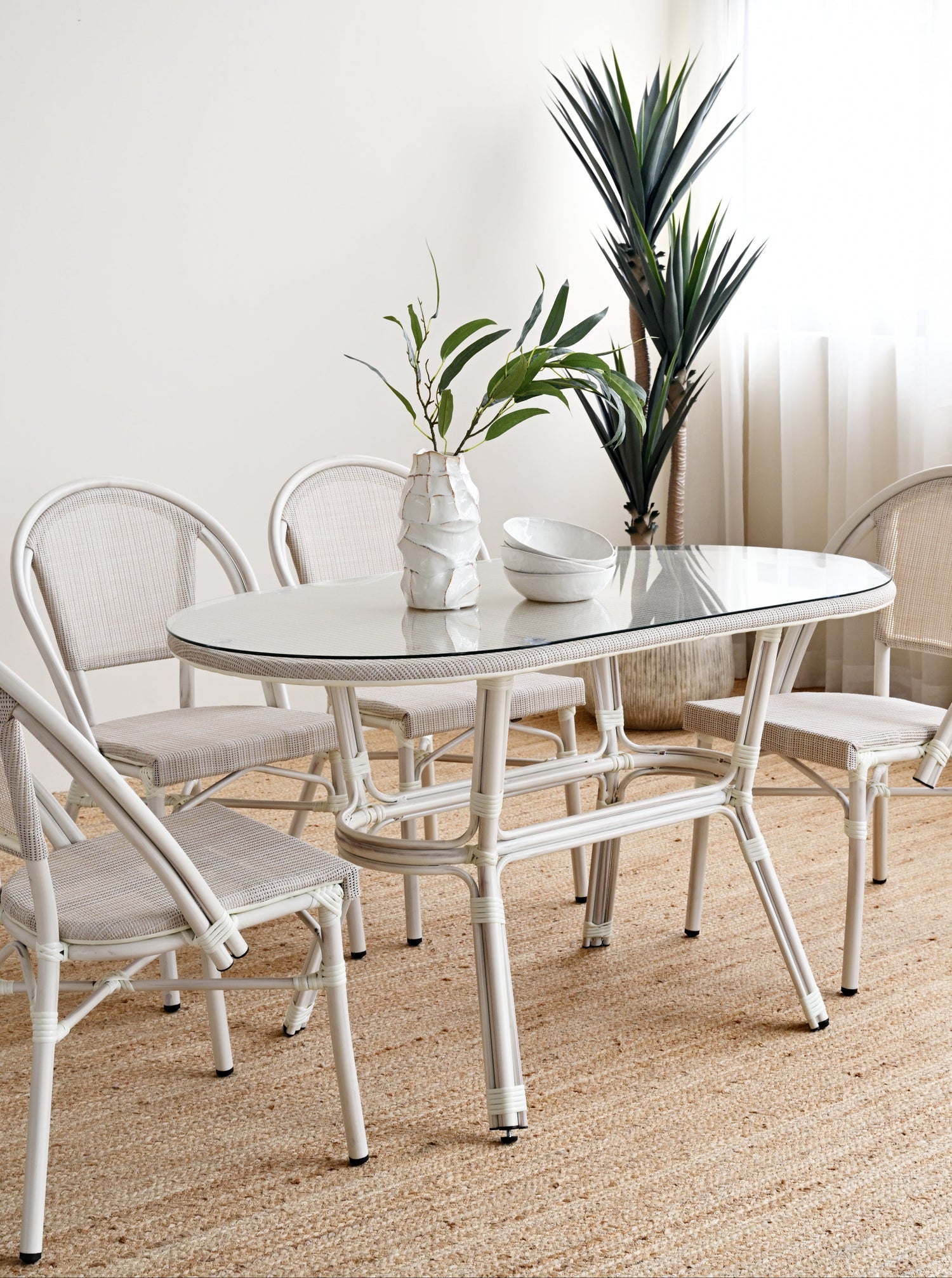 White dining set with table and chairs in a bright room