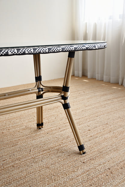 Small round table with a checkered top on a carpeted floor.