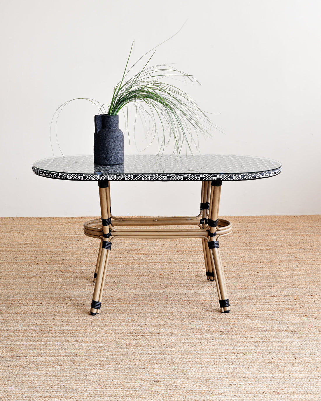 Round marble table with gold legs on a wooden floor against a white wall