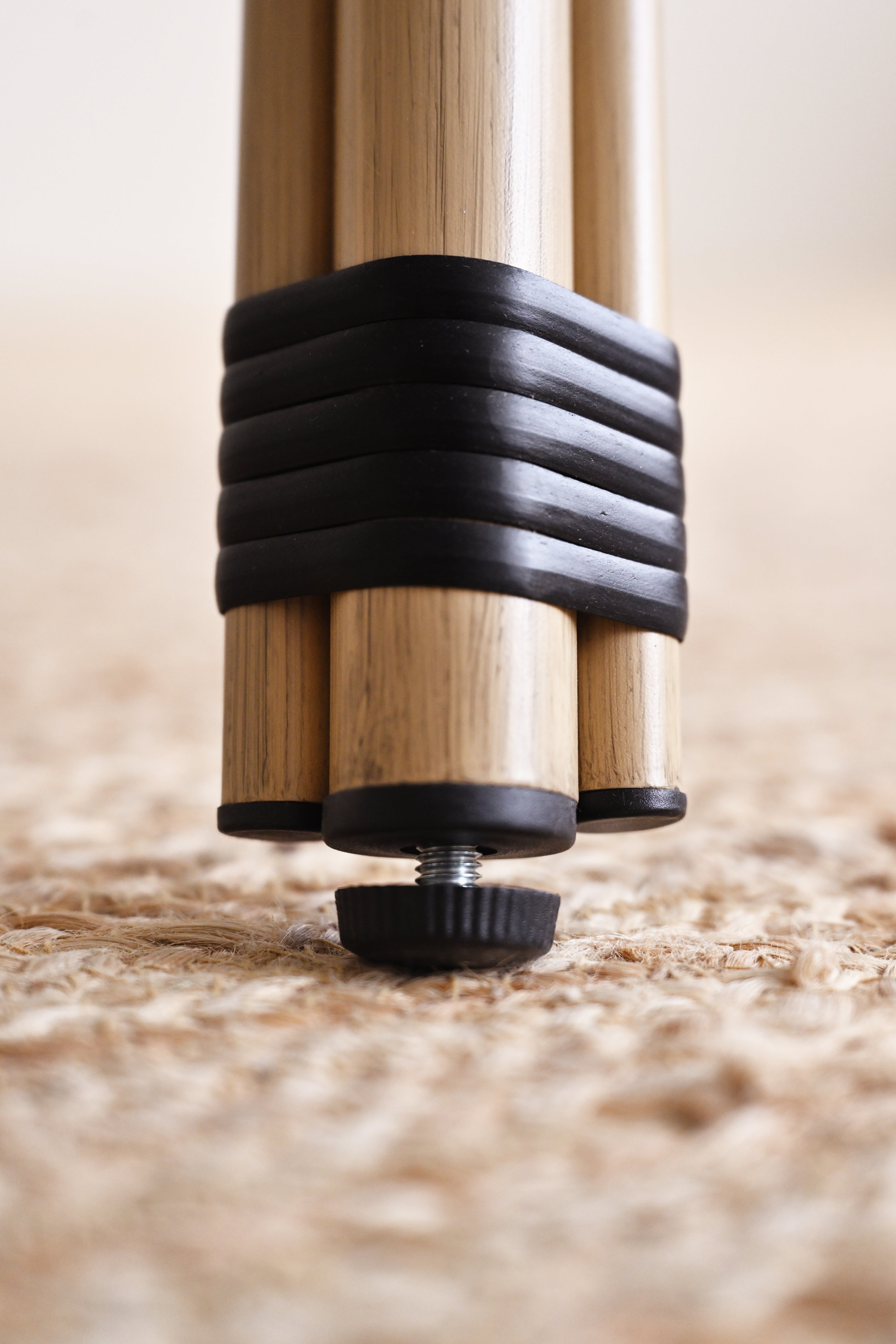 Close-up of a wooden leg with a black rubber foot on a wooden floor.