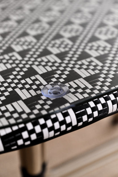 Close-up of a black and white patterned table surface with a clear plastic knob.
