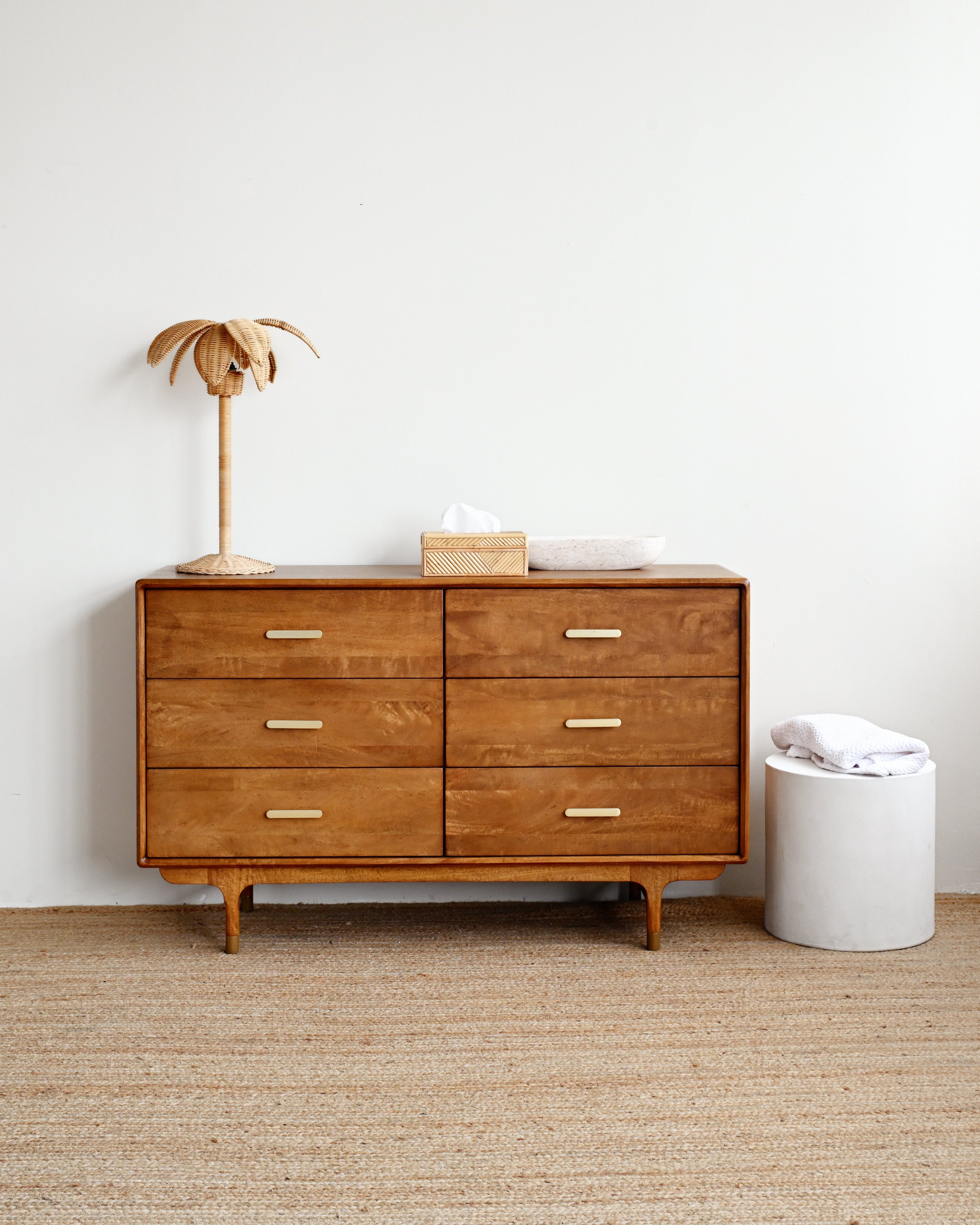Wooden dresser with decorative items against a white wall
