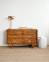 Wooden dresser with decorative items against a white wall