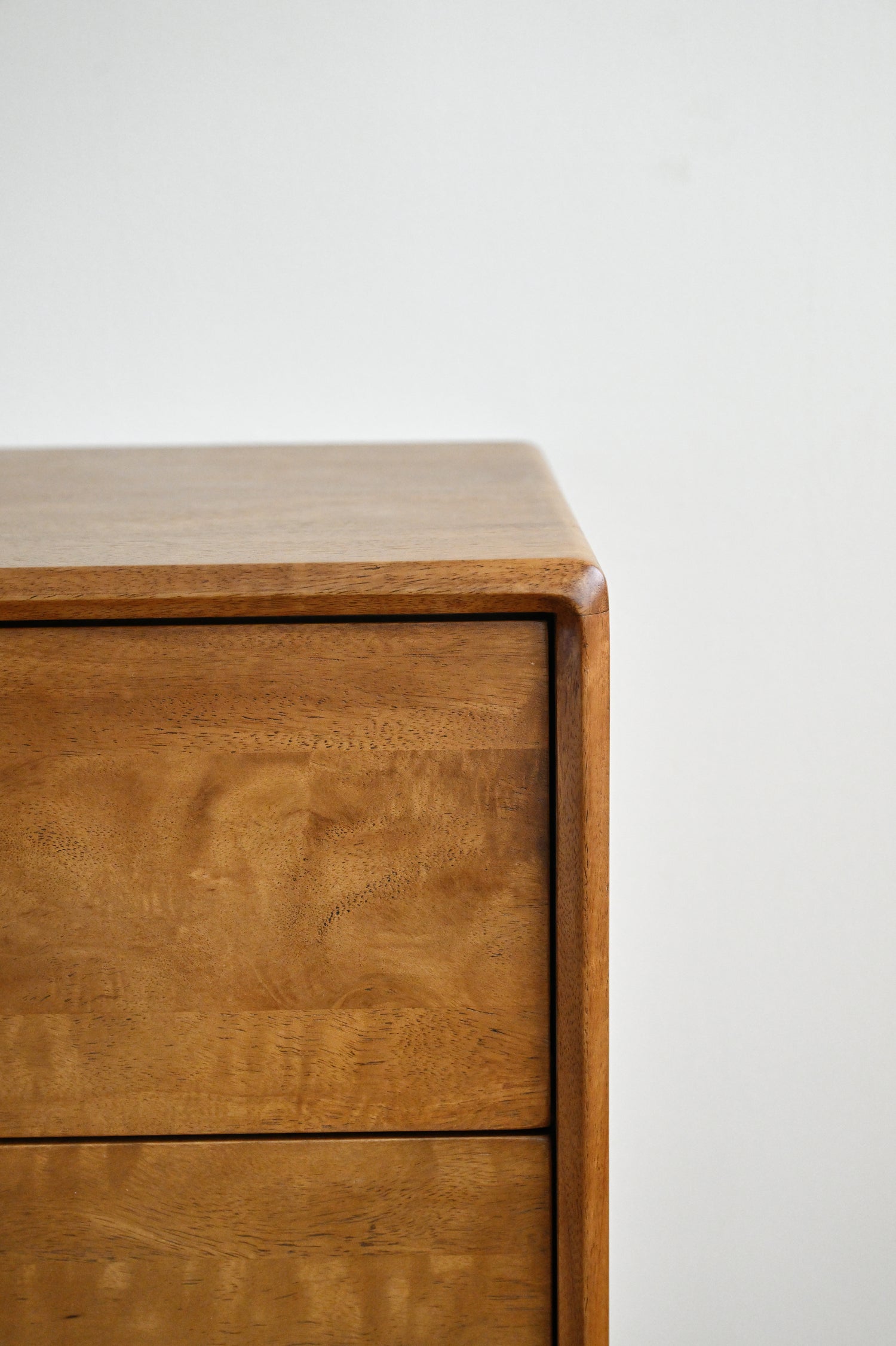 Wooden dresser with a light finish on a white background