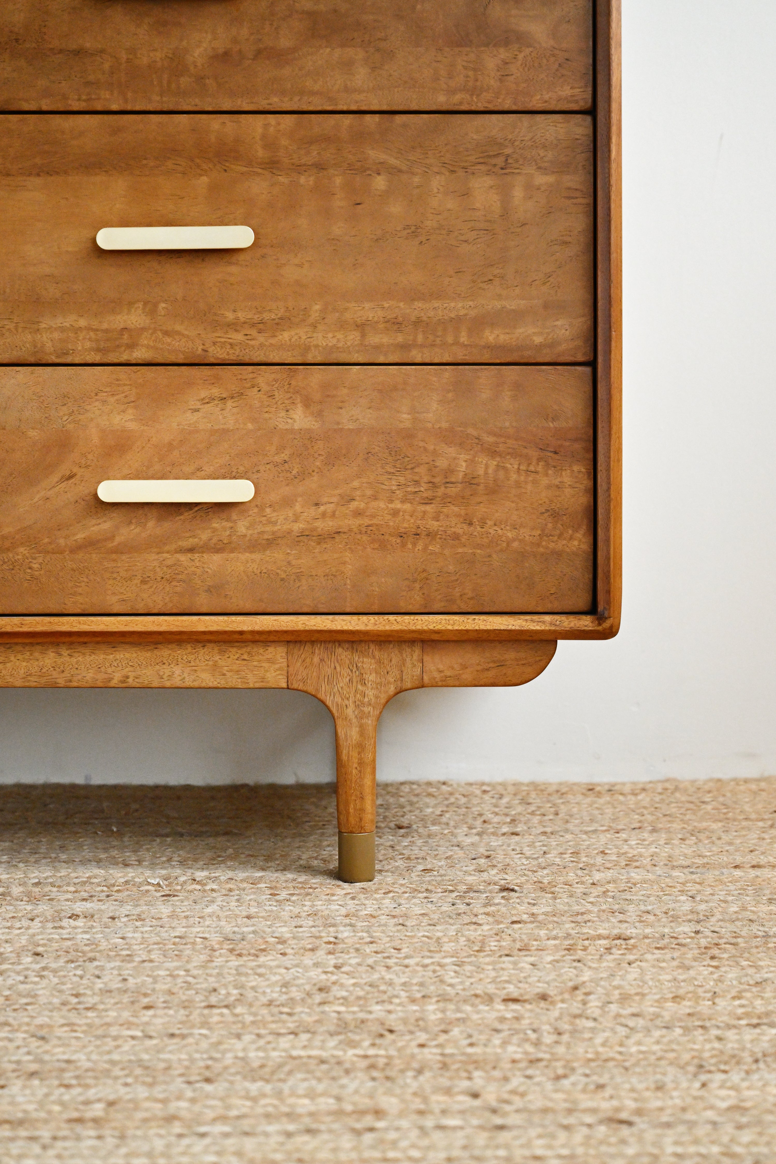 Wooden dresser with two drawers on a textured surface.