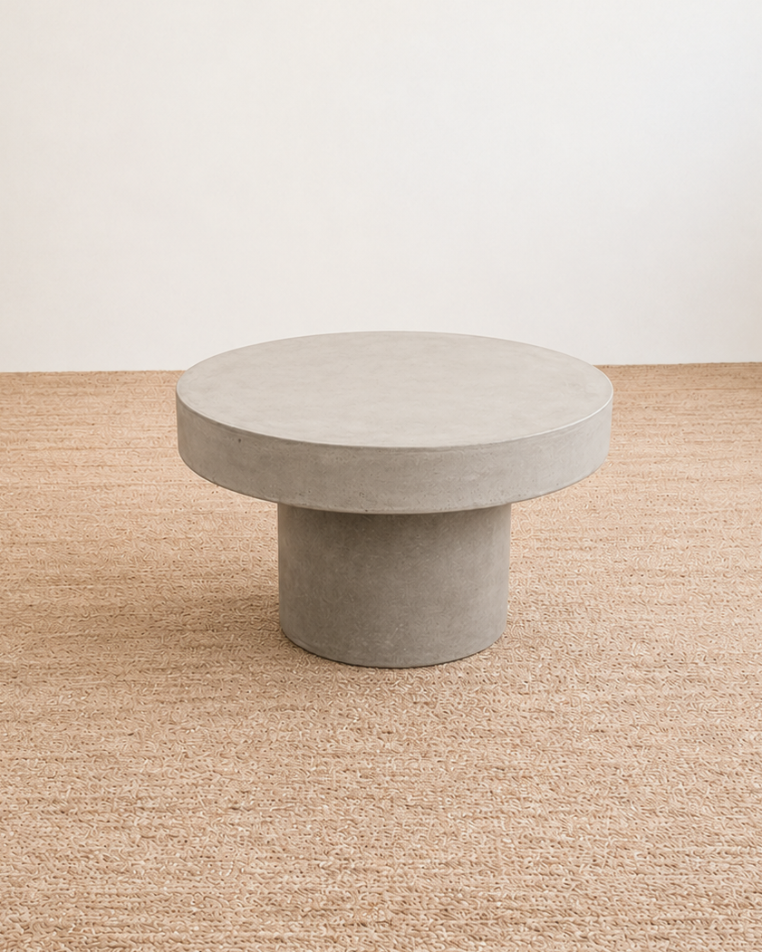 Concrete coffee table on a beige carpet with a white wall background
