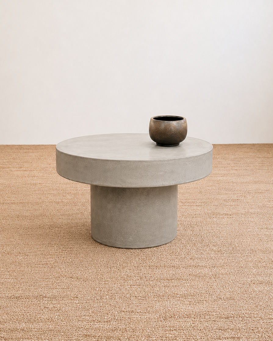Concrete coffee table with a vase on a textured beige floor and white wall