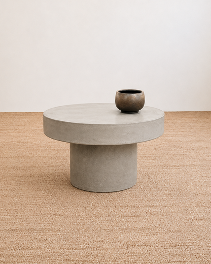 Concrete coffee table with a vase on a textured beige floor and white wall