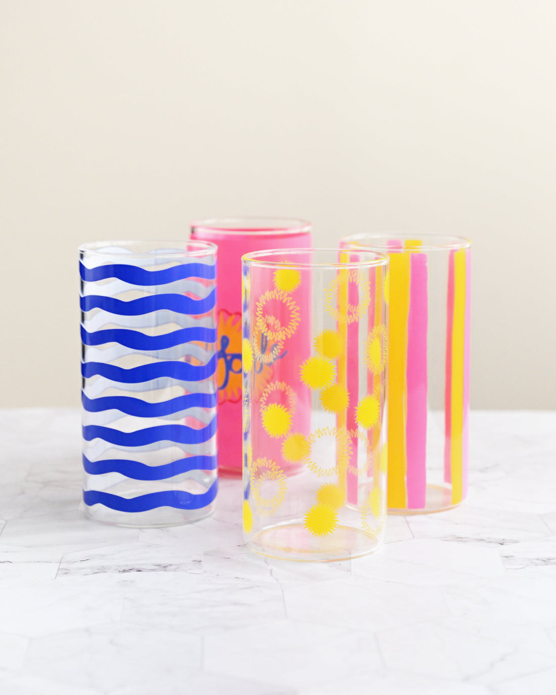 Four colorful tumblers with different patterns on a white surface
