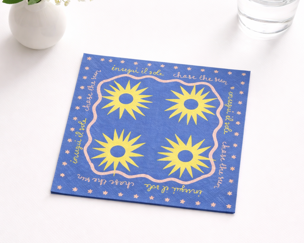 Blue napkin with yellow sun patterns on a white surface