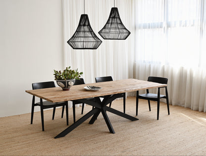 Dining room with a wooden table and black chairs under two black pendant lights.